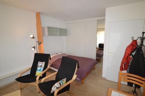 une chambre avec un lit et deux chaises dans l'établissement Comfortable studio near the beaches, à Cannes