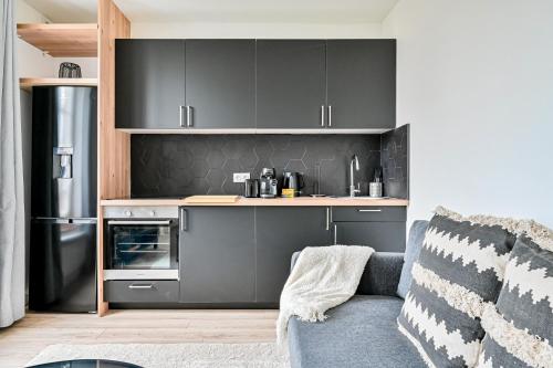 - une cuisine avec des placards gris et un réfrigérateur dans l'établissement Ptit Villemomble - Wifi - Paris & Disney, à Villemomble