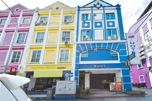 un edificio colorato con sopra un orologio di Brilliant Empire Hotel a Malacca