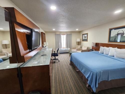 um quarto de hotel com uma cama e uma televisão de ecrã plano em Windsor Place Inn em Prairie du Chien