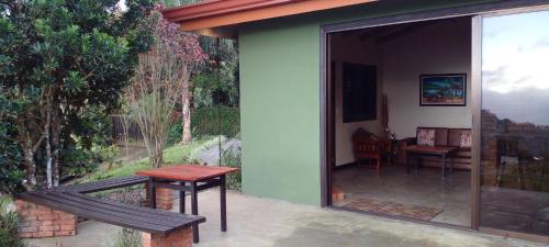 a patio with a table and a bench on a patio at Paraiso Del Cielo in San Ramón