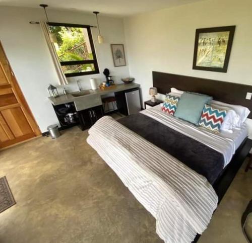 a bedroom with a large bed and a desk at Paraiso Del Cielo in San Ramón