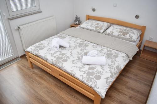 ein Schlafzimmer mit einem Bett mit zwei Handtüchern darauf in der Unterkunft Apartmani Vila in Kupres