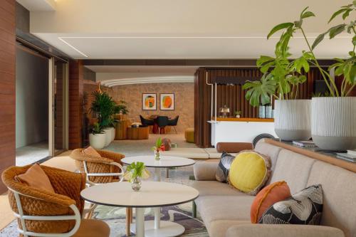 a lobby with a couch and tables and chairs at The Ambassador of Waikiki, Tapestry Collection by Hilton in Honolulu