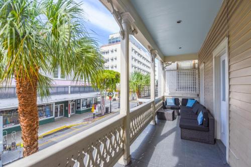a balcony with a palm tree and a train at Duval Dream Loft on Duval in Key West