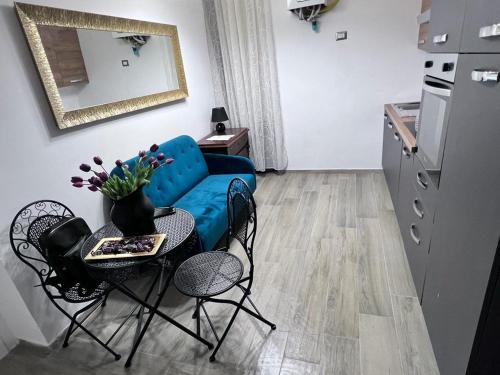 a living room with a blue couch and a table and chairs at Guest House Biondi Cavour in Rome