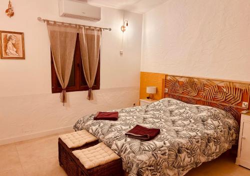 un dormitorio con una cama y una ventana en Maison à Gordes dans le Lubéron, en Gordes