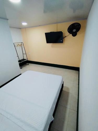 a hospital room with a bed and a television at Celestino - Casa de Huespedes in Guaduas