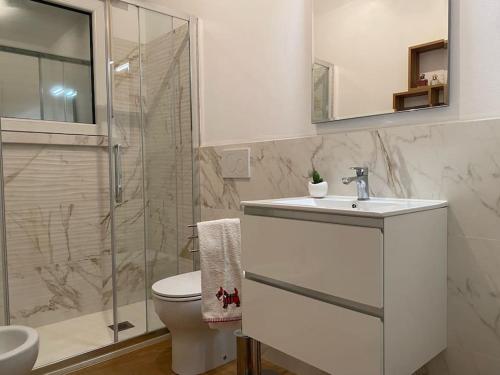 uma casa de banho com um WC, um lavatório e um chuveiro em Appartamento Luxury White em Viareggio