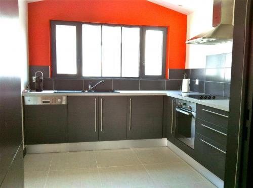 - une cuisine avec un évier et un mur orange dans l'établissement Les Villas de l'Embarcadère Villa La Serpent, à La Flotte