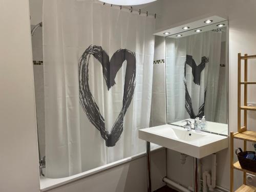 a bathroom with a heart drawn on the shower curtain at Beau F2 du hameau avec parking in Meaux