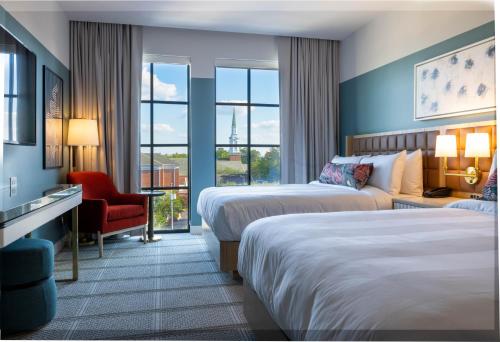 una habitación de hotel con 2 camas y una silla en The Alamite, Tuscaloosa, a Tribute Portfolio Hotel, en Tuscaloosa