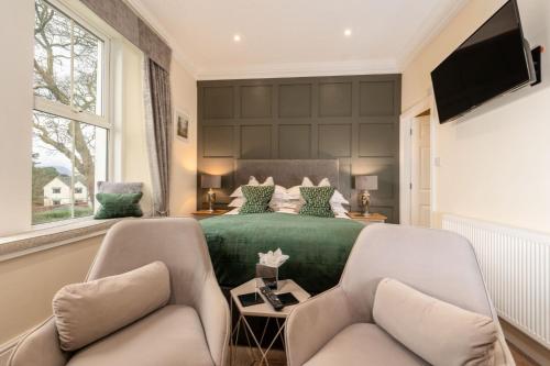 a bedroom with a green bed and two chairs at Wheatlands Lodge Guesthouse - Adults Only - Free car park - Licensed Venue in Windermere