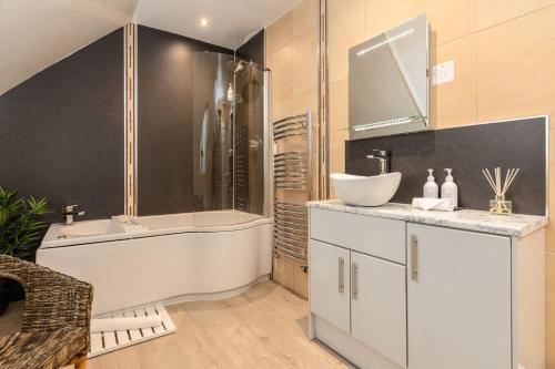 a bathroom with a tub and a sink and a bath tub at Wheatlands Lodge-Windermere - Award Winning - Adult Only - Car Park in Windermere