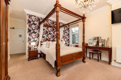 a bedroom with a four poster bed and a chandelier at Wheatlands Lodge-Windermere - Award Winning - Adult Only - Car Park in Windermere