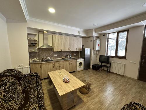 a living room with a table and a kitchen at Jermuk Mini Apartment in Jermuk