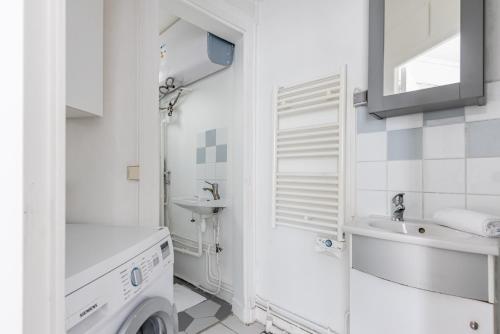 La salle de bains blanche est pourvue d'un lavabo et d'un lave-linge. dans l'établissement Loft Magenta Blue, à Paris