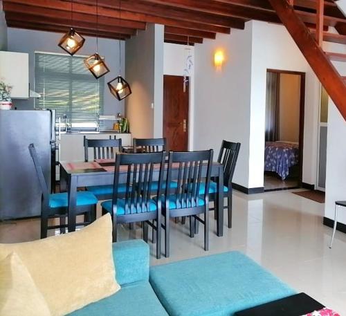 comedor con sillas azules y mesa en Lakeville Residence en Nuwara Eliya