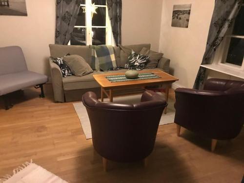 uma sala de estar com um sofá, uma mesa e cadeiras em 8 bed house in Vik, Åre em Åre