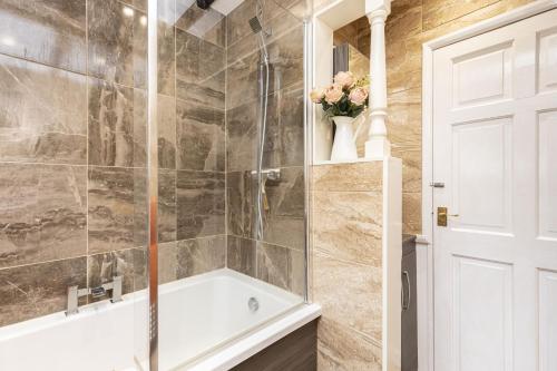 a bathroom with a shower with a bath tub at Cozy Cottage, Secure Garden, Dog Freindly in Bournemouth