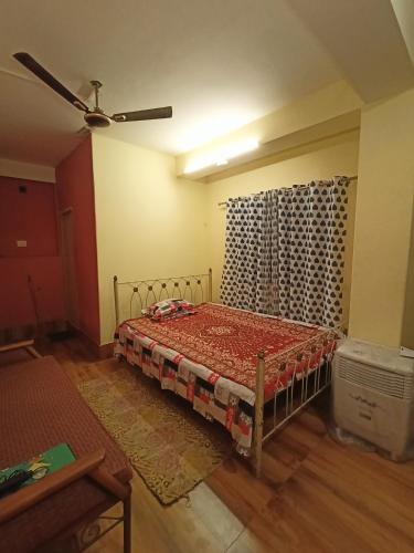 1 dormitorio con 1 cama y ventilador de techo en Buddha Kuthir, en Dām Dim