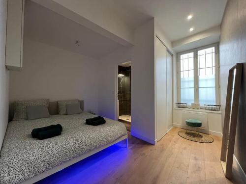 une chambre avec un grand lit avec des lumières bleues dessus dans l'établissement Havre de Paix - Melun, à Melun