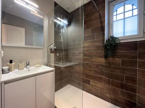 une salle de bain avec un lavabo et une douche en verre dans l'établissement Havre de Paix - Melun, à Melun