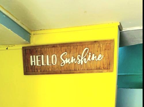 a sign that reads hello sunshine on a yellow wall at Beachfront Cozy Apt in Gros Islet