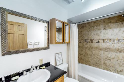 ein Badezimmer mit einem Waschbecken, einer Badewanne und einem Spiegel in der Unterkunft Blue Mountain Magic in Blue Mountains
