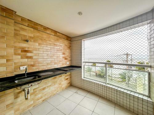 ein Bad mit einem Waschbecken und einem Fenster in der Unterkunft Apto a beira mar da Praia de Vera Cruz,Mongagua SP in Mongaguá