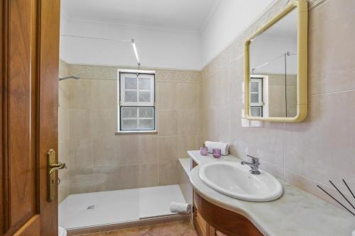 a bathroom with a sink and a tub and a mirror at Villa Casa do Barrocal by Villa Plus in Loulé
