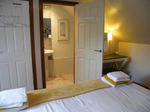 Schlafzimmer mit einer Tür zum Bad in der Unterkunft Kirkside in Auchterarder