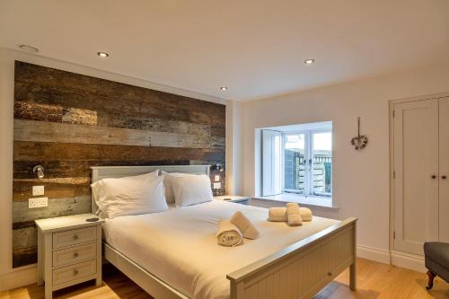 a bedroom with a large bed with a wooden wall at Finest Retreats - Dingles Cottage in Philleigh