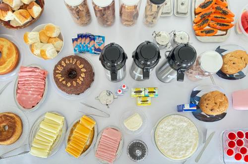 een tafel met verschillende soorten taarten en gebak bij Pousada Natalli in Cabo Frio