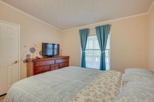 a bedroom with a bed and a tv on a dresser at Lake Livingston Home with Dock and Deck! in Huntsville