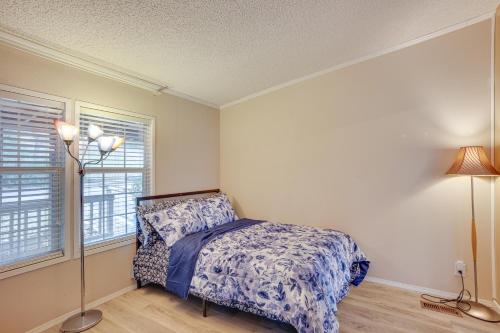 a bedroom with a bed and two windows at Lake Livingston Home with Dock and Deck! in Huntsville