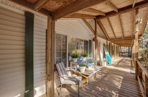 a covered porch with chairs and a table with flowers at Lake Livingston Home with Dock and Deck! in Huntsville