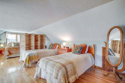 a bedroom with two beds and a mirror at Riverfront Kingston Cottage w/ Deck, 2 Mi to Beach in Kingston