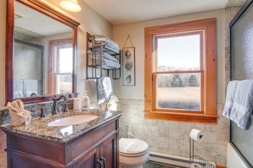 a bathroom with a sink and a toilet and a mirror at Riverfront Kingston Cottage w/ Deck, 2 Mi to Beach in Kingston