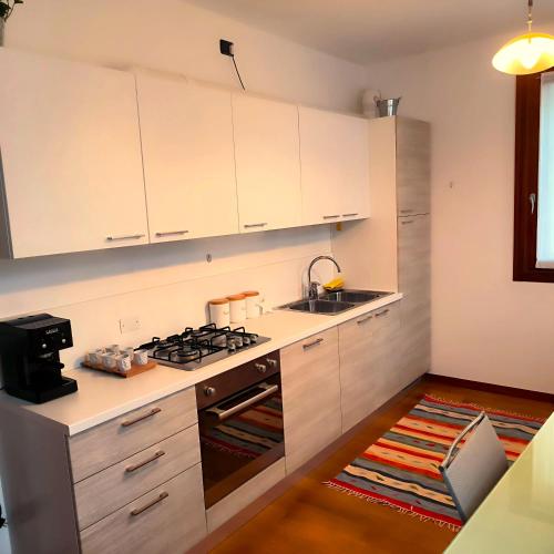 a kitchen with white cabinets and a stove top oven at Ex Casa degli Artisti in Montebelluna