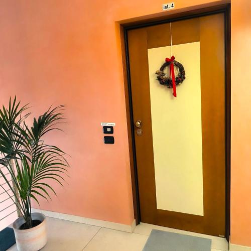 a door with a wreath and a plant next to it at Ex Casa degli Artisti in Montebelluna