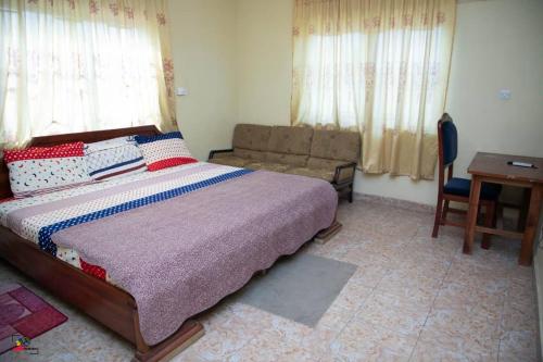 Jukambo Lodge : غرفة نوم بسرير واريكة وطاولة