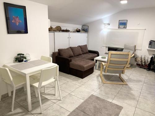 uma sala de estar com um sofá, uma mesa e cadeiras em Apartman Dunav em Rospi Ćuprija