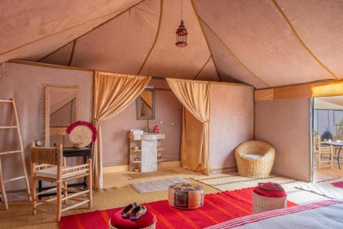 a bedroom in a tent with a table and a desk at Sanmao Royal Camp 皇家营地 in Merzouga