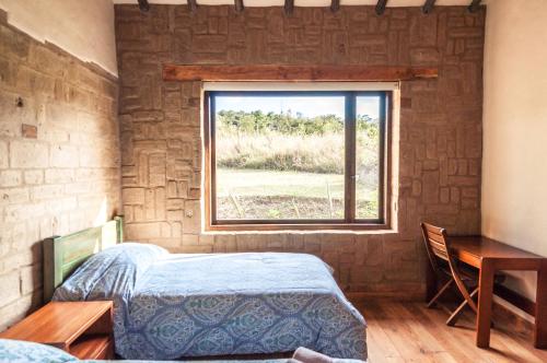1 dormitorio con cama y ventana en ANNAPURNA Villa de Leyva, en Villa de Leyva