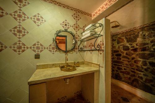 a bathroom with a sink and a mirror on the wall at Ouednoujoum Ecolodge & Spa in Ouarzazate