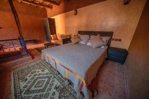 Ouednoujoum Ecolodge & Spa في ورززات: غرفة نوم بسرير كبير في غرفة