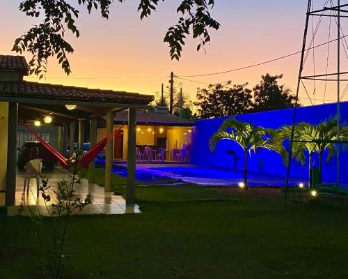 een blauw huis met palmbomen ervoor bij Recanto das Margaridas in Pindoretama