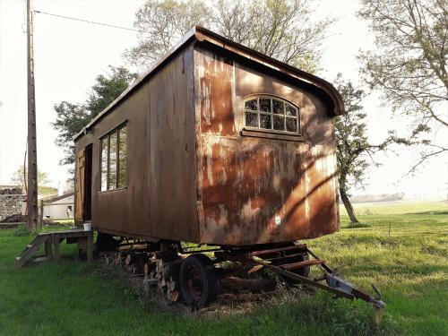 une vieille voiture de train assise dans un champ dans l'établissement la Roulotte de la Borde, à Roubert