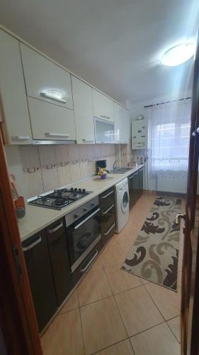 cocina con armarios blancos y fogones en Apartament AKM, en Târgu Ocna